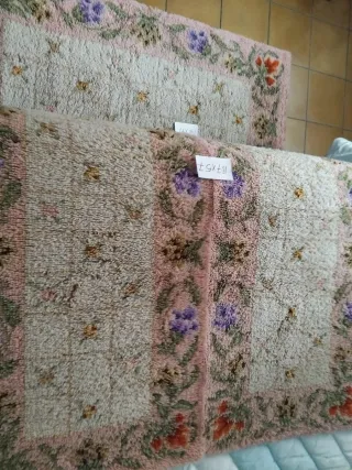 Alfombra de lana rosa con flores como nuevas.