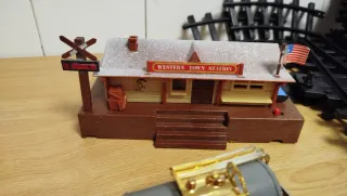 Tren de juguete antiguo con estación y vías