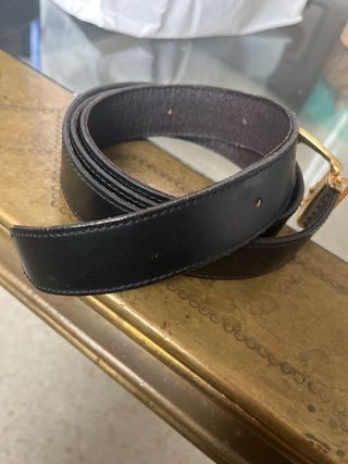 Cinturón de cuero negro con hebilla dorada