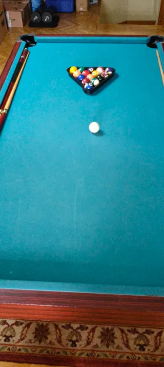 Mesa de billar , con tres palos y las bolas .