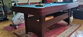 Mesa de billar , con tres palos y las bolas .