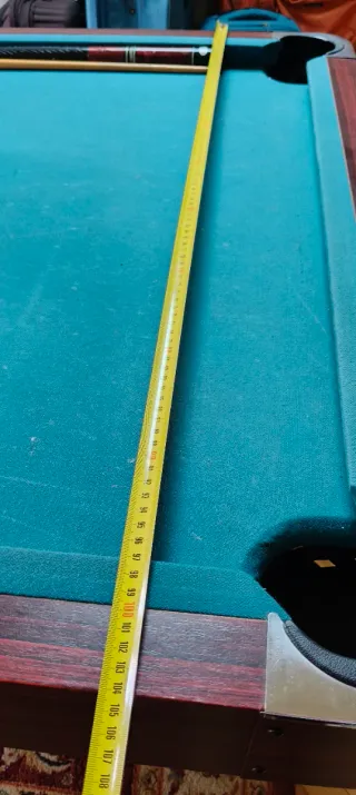 Mesa de billar , con tres palos y las bolas .