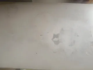 Mesa de entrada blanca con cajones gris.