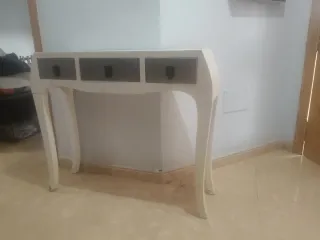 Mesa de entrada blanca con cajones gris.