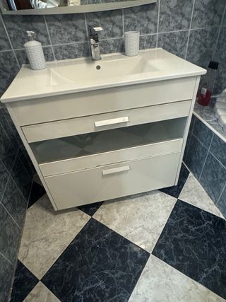 Mueble de baño blanco y gris con lavabo y grifo