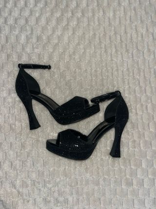 Elegantes tacones altos negros brillantes
