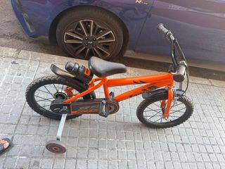 Bicicleta infantil naranja con ruedines