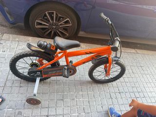 Bicicleta infantil naranja con ruedines