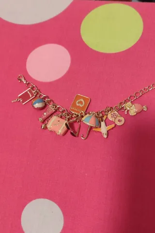 Pulsera dorada con charms de viaje sin estrenar