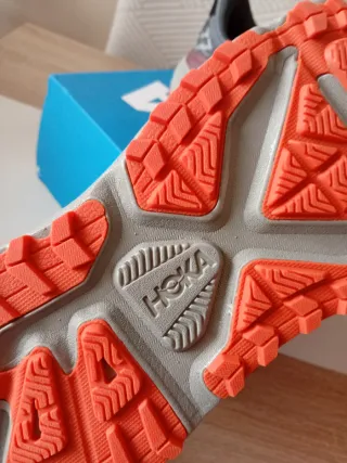 Zapatillas Hoka grises y naranjas