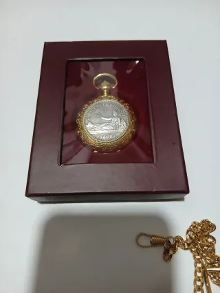 Reloj de bolsillo dorado con moneda