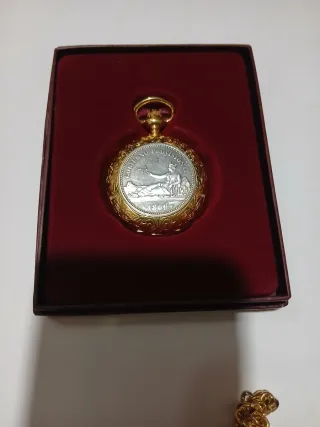 Reloj de bolsillo dorado con moneda