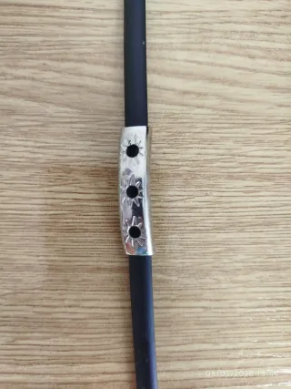 Pulsera negra con detalle metálico