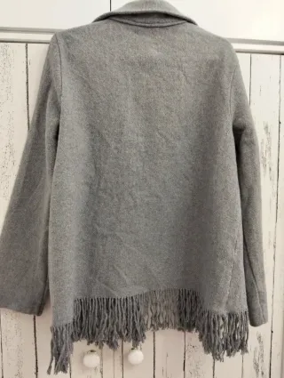 Chaqueta de paño gris con flecos.