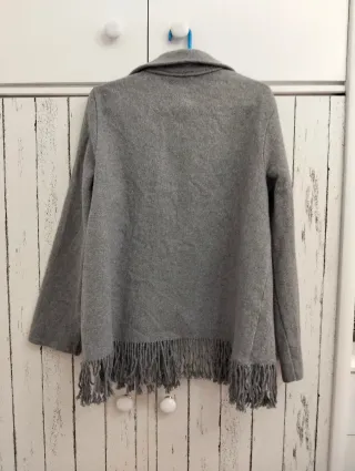 Chaqueta de paño gris con flecos.
