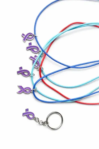 Collares y llaveros solidarios morados