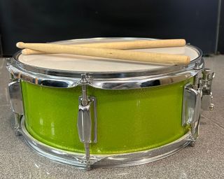 Tambor infantil verde con baquetas