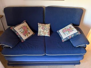 Sofá azul de tela con cojines