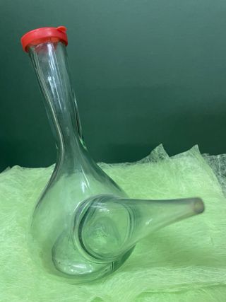 Porrón antiguo de cristal con tapón rojo