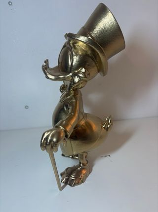 Zio Paperone con in mano il suo primo centesimo