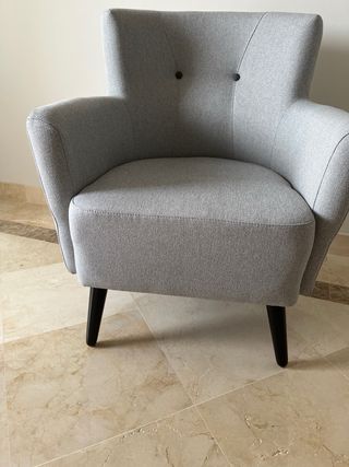Sillón de tela gris con patas de madera en negra