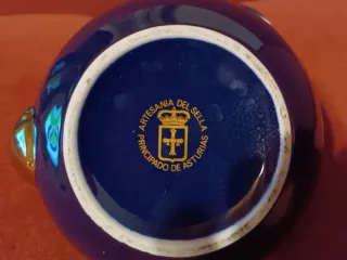 Tetera azul y dorada con asa de madera