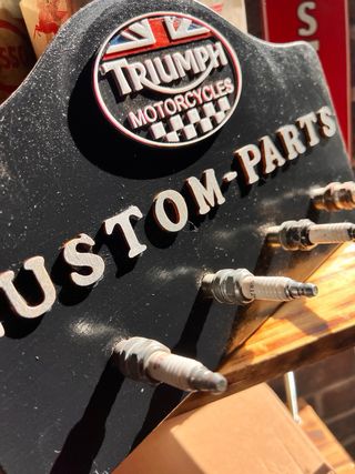 Cartel Triumph Custom Parts con bujías