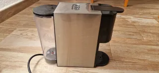 Cafetera de cápsulas y cafe naturar plateada