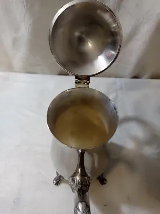 Jarra de metal plateado con patas