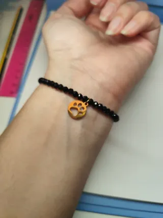 Pulsera negra con charm de gato dorado