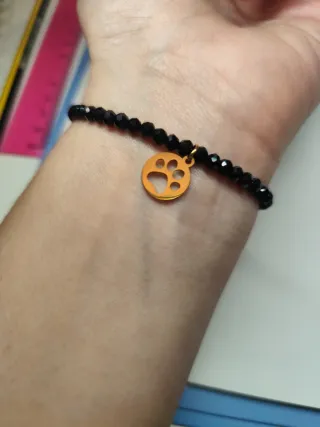 Pulsera negra con charm de gato dorado