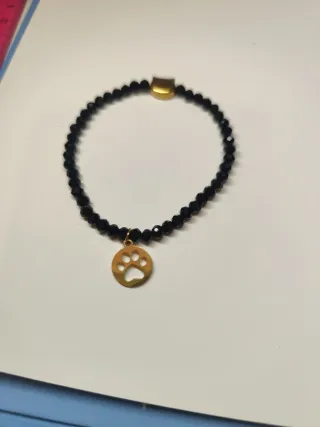 Pulsera negra con charm de gato dorado