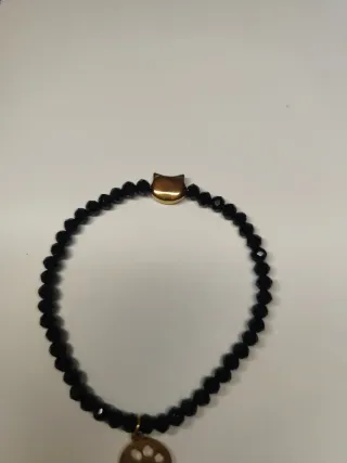 Pulsera negra con charm de gato dorado
