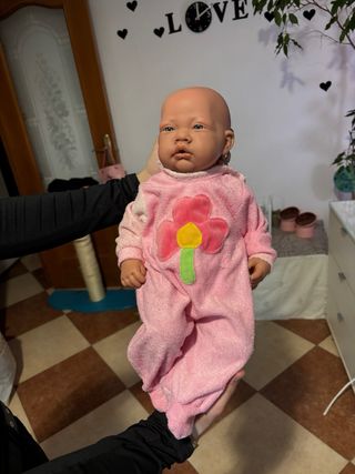Bebe reborn rosa con flor