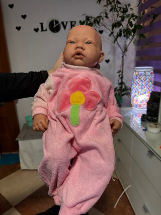 Bebe reborn rosa con flor