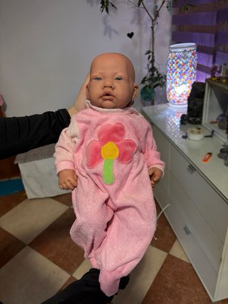 Bebe reborn rosa con flor