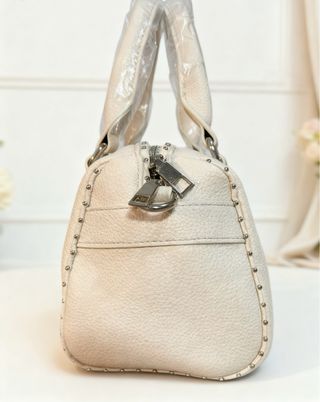 Bolso color crudo con tachuelas plateadas