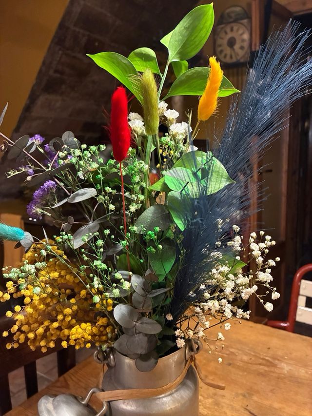 Lechera antigua con flores preservadas