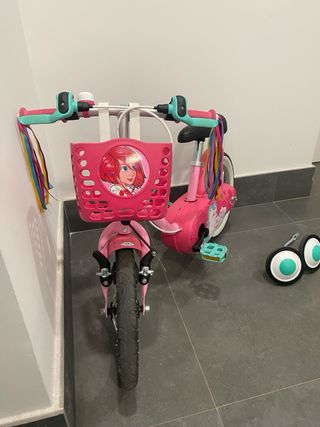 Bicicleta infantil rosa con ruedines y cesta