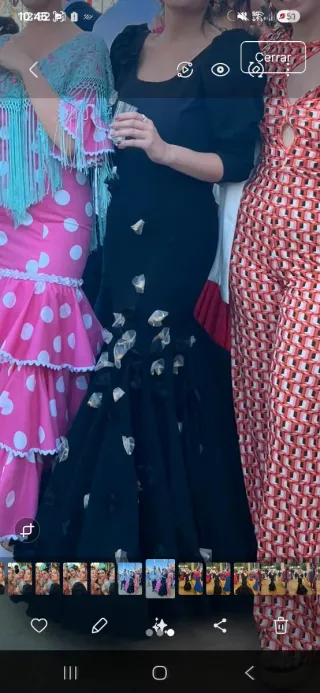 Traje de flamenca negro con flores y manga jamón.