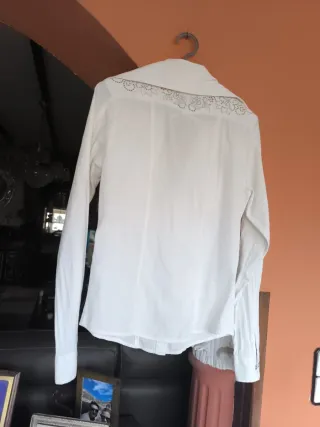 Blusa blanca con pedrería y logo