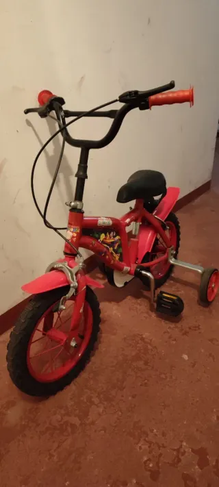 Bicicleta infantil roja con ruedines