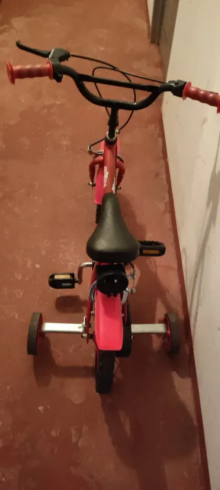 Bicicleta infantil roja con ruedines
