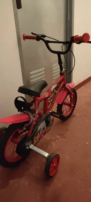 Bicicleta infantil roja con ruedines