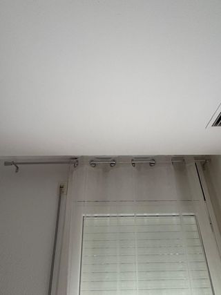 Cortinas beige y barras plateadas