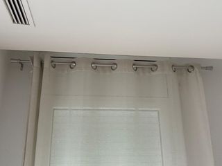 Cortinas beige y barras plateadas