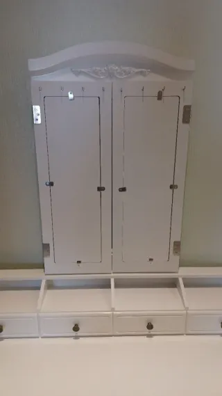 Tocador blanco con espejo y taburete.