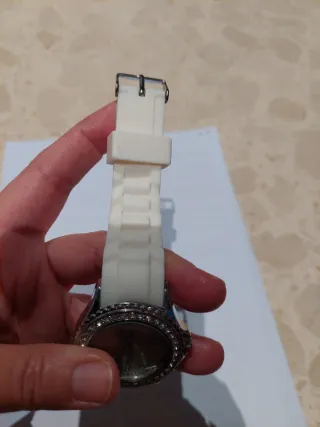 Reloj blanco con correa de goma y detalles brillan