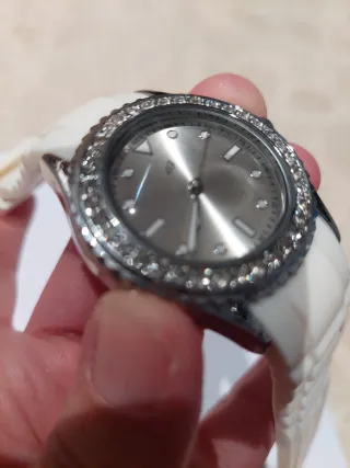 Reloj blanco con correa de goma y detalles brillan