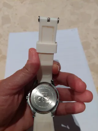 Reloj blanco con correa de goma y detalles brillan